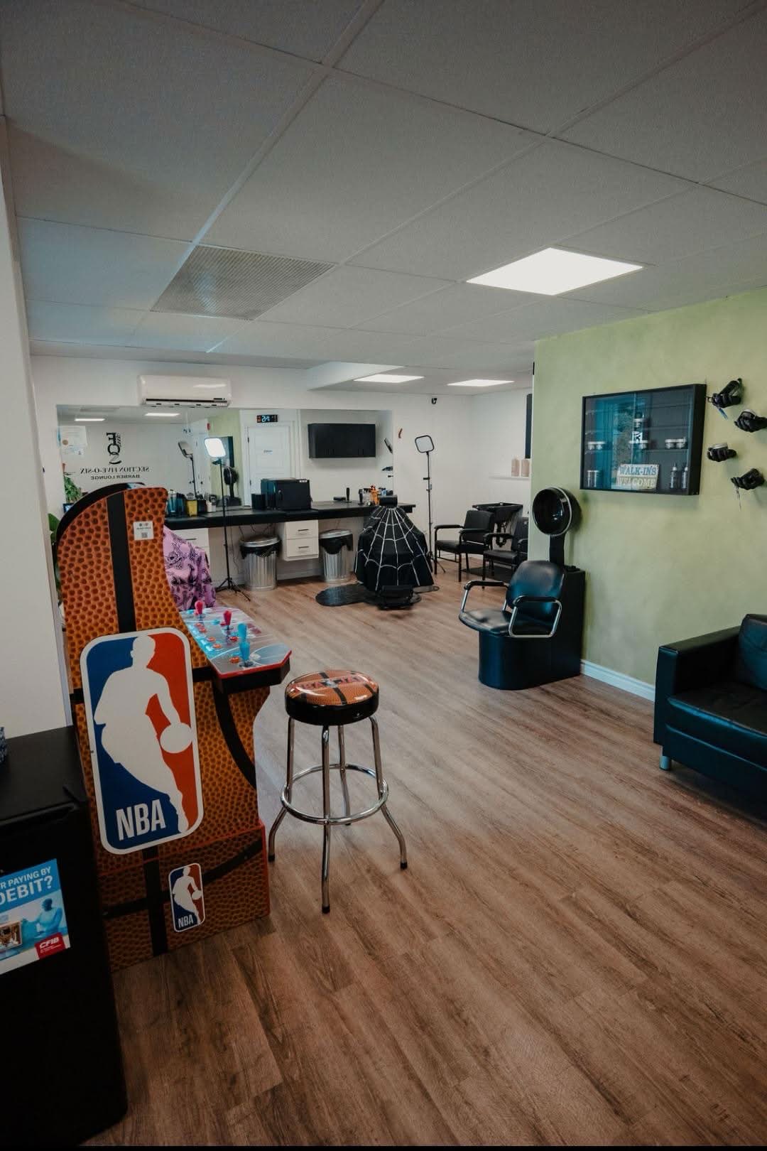 The NBA Jam arcade cabinet and stool in the waiting area