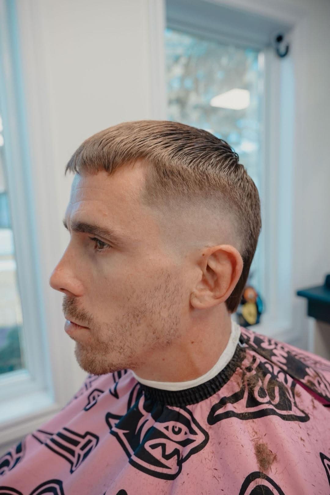 Finished high skin fade with a combed side part, side profile